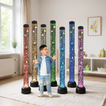 Multiple bubble tubes illuminate in rainbow colors behind a child standing in a living room.