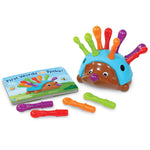 Spike the Fine Motor Hedgehog sits next to the book "First Words With Spike!"