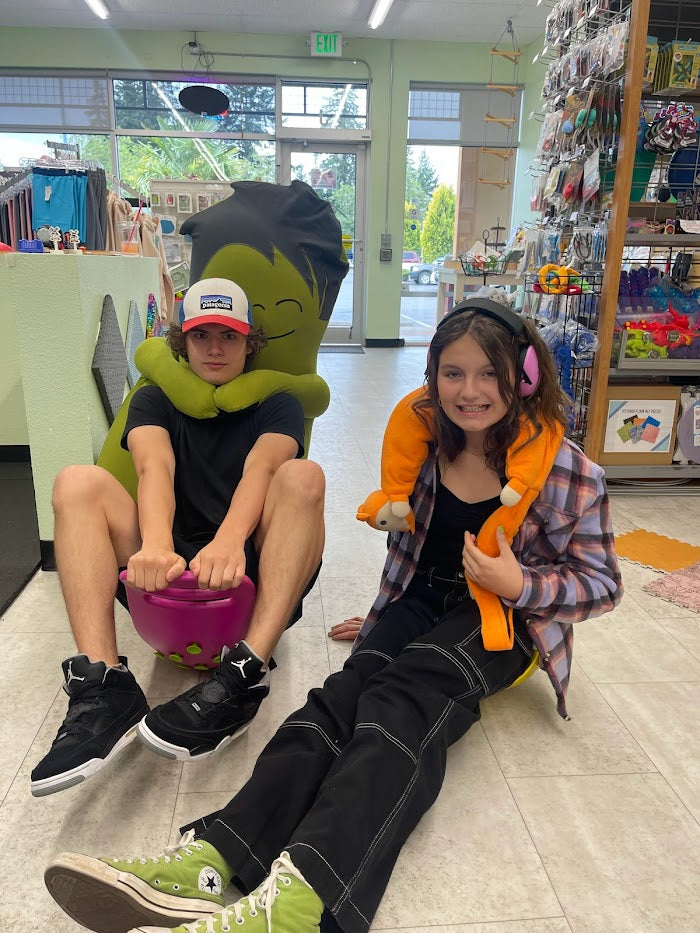 Two teens sitting on the floor with toys and sensory tools