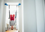 Child hanging upside down on the Deluxe Doorway Swing.