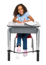 Child sitting at a desk with her foot on the Bouncyband for School Desks