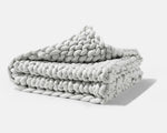 A folded Soft Grey Gravity Chunky Knit Weighted Blanket.