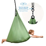A child looks like they are flying while laying belly-down in the Green Harkla Sensory Compression Swing with Swivel.