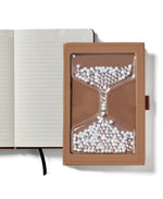 The cover of the "Take Your Time" Tactile Sensory Journal in front of an embossed page.