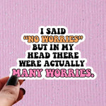 A hand holds up a sticker that reads: I Said "No Worries" But In My Head There Were Actually Many Worries.