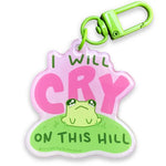A small green frog with huge teary eyes sits on a green hill surrounded by the text: I will cry on this hill.