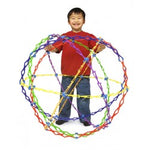 A child smiling and holding an expanded Hoberman Sphere. The child is standing inside the sphere.