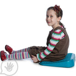 Child sitting on the Lean N Learn Wedge Cushion.