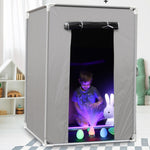 A child inside the 6 ft Blackout Sensory Tent. The child is playing with a fiber optic light lamp that is surrounded by LED light up eggs.