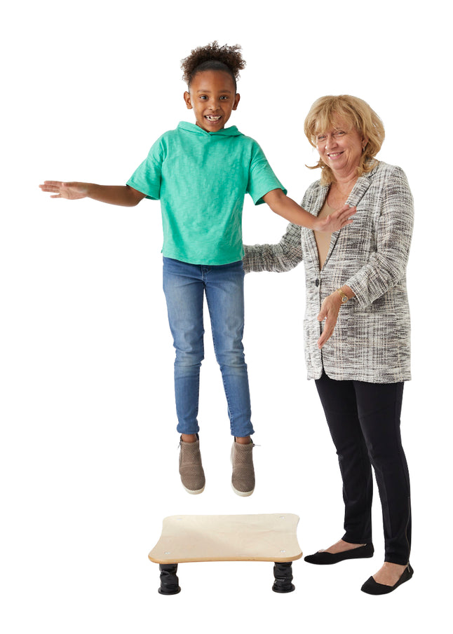 Child jumping on a bouncing board with an adult watching and smilling