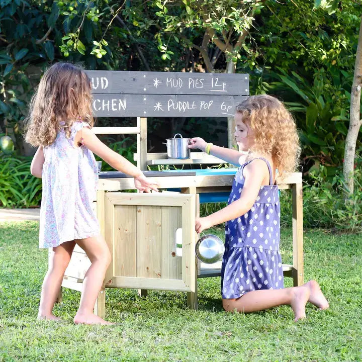 Two children playing with a wooden mud kitchen