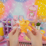 A hand stretches the orange Gummy Unicorn Friend.