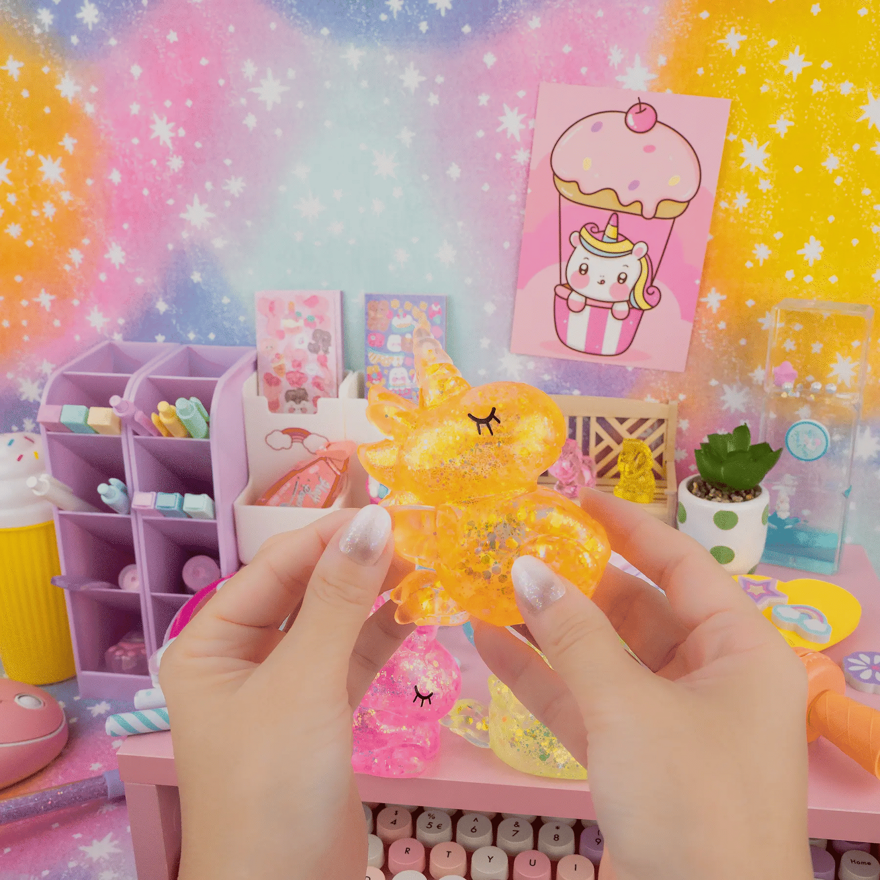 A hand stretches the orange Gummy Unicorn Friend.
