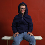 A man smiles with the hood up on his Navy QuietSense Zippered Sound Reducing Sensory Hoodie.