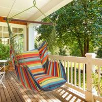 The Rainbow Hammock Chair hangs on a covered porch.