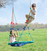 One child sits on the swing and leans back on the climbing nets. Another child climbs the net and reaches the top.