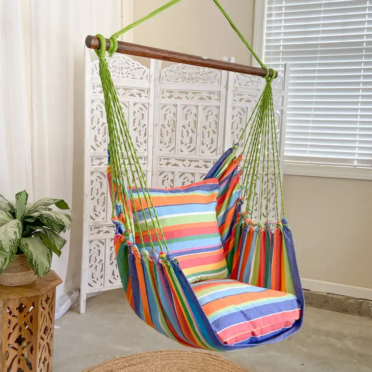The Rainbow Hammock Chair hangs in a white indoor space.