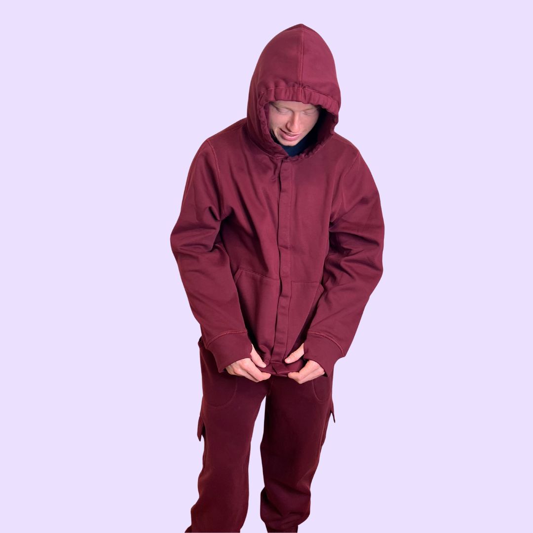 An adult fidgets with the Maroon Sensory Hoodie for Adults' magnetic snap closures.
