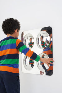 A child stands in front of the Large 4 Bubble Dome Sensory Mirror.