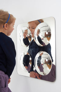 A child makes faces in front of the Large 4 Bubble Dome Sensory Mirror.