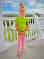 A child wearing the lime green Kozie 4-Way Nylon Classic Plain and Simple Compression Short Sleeve Shirt.