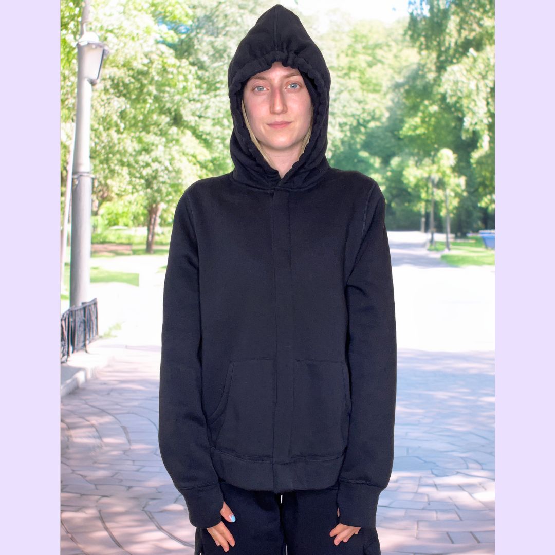 An adult uses the thumb holes of the Navy Sensory Hoodie for Adults.