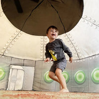 A child with light skin tone and short brown hair is in an action mode, as though about to start running, under the dome of the UFO AirFort.