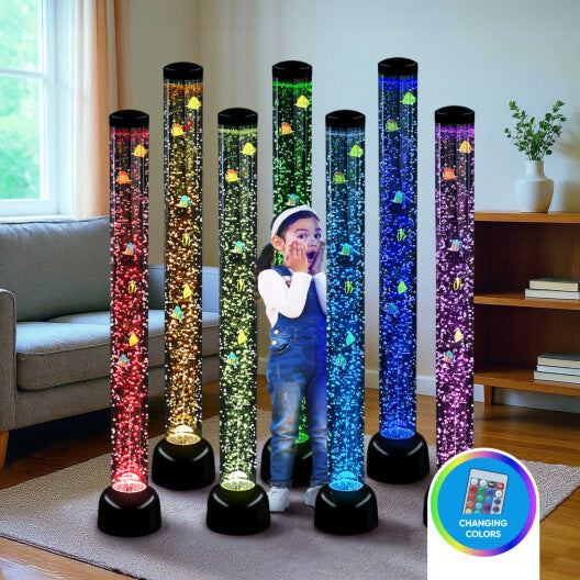 Multiple bubble tubes illuminate a rainbow color behind a child holding her hands up to her face in a living room.