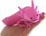 A hand with light skin tone holds up a pink Wiggle Sensory Axolotl.