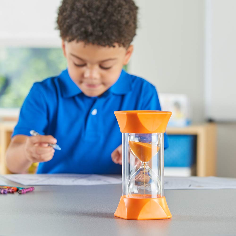 A child with medium-dark skin sits in the background with a crayon in their hand. The orange Jumbo 5 Minute Timer sits in the foreground.