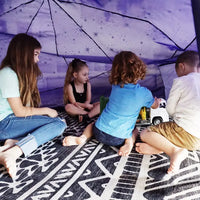 Four children sit inside of the Starry Night AirFort.