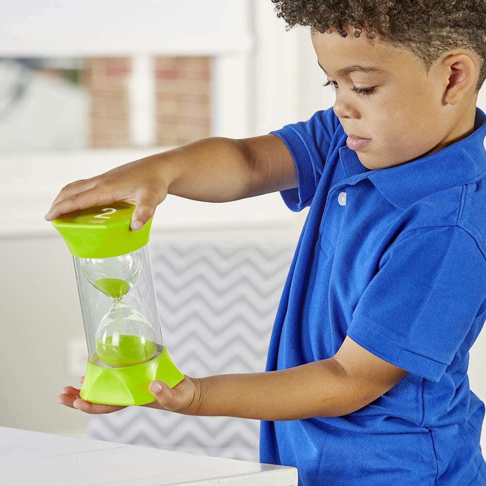 A child with medium-dark skin tone and short curly hair holds up the Jumbo 2 Minute Sand Timer with both hands on either side of the timer.