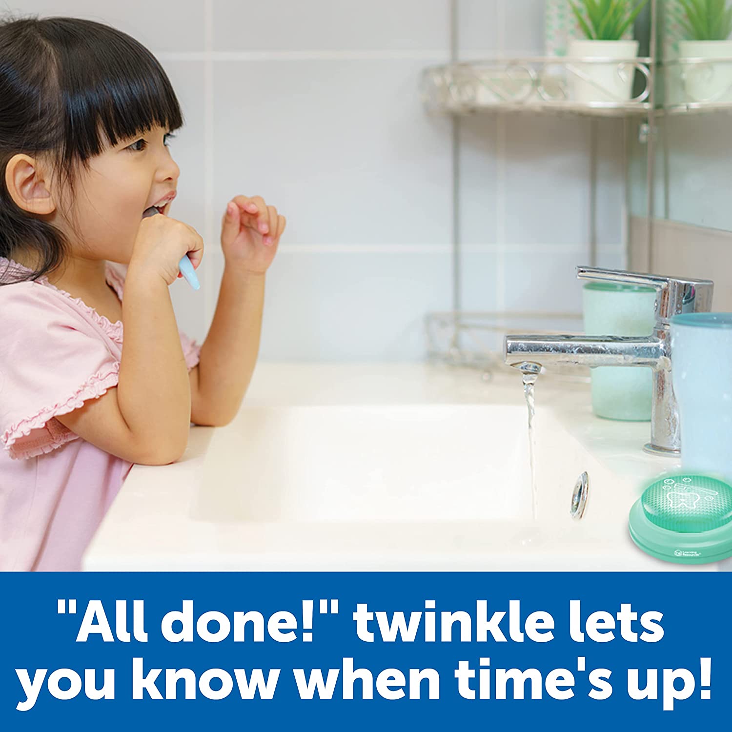 A child with medium skin tone and black hair is in front of a sink in the bathroom brushing their teeth. There is a Toothbrush Timer on the sink ledge.