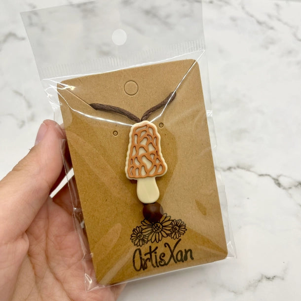 The Morel Mushroom Fidget Necklace in its packaging.