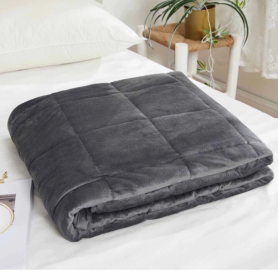 The grey Antimicrobial Plush Mink Weighted Blanket 12 lb folded neatly on a made bed.
