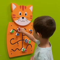 A child with light skin tone and short brown hair moves a number tile on the Cat Activity Wall Panel.