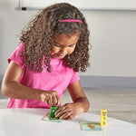 A child with medium skin tone and shoulder length brown, curly hair plays with the Four in the Mathlinks Cubes, Numberblocks 1-10.