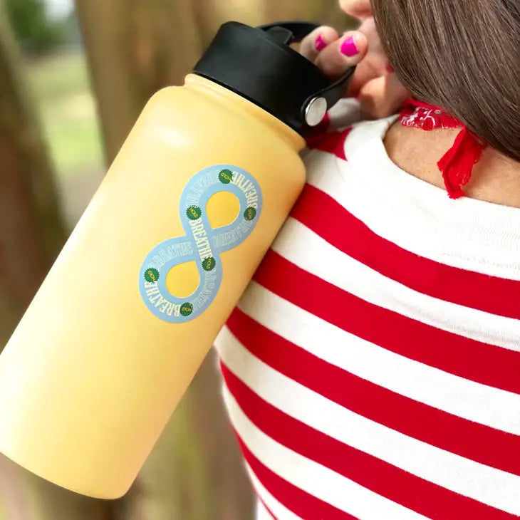 The Breathe Reusable Sensory Sticker on the back of a yellow water bottle, carried over someone's shoulder.