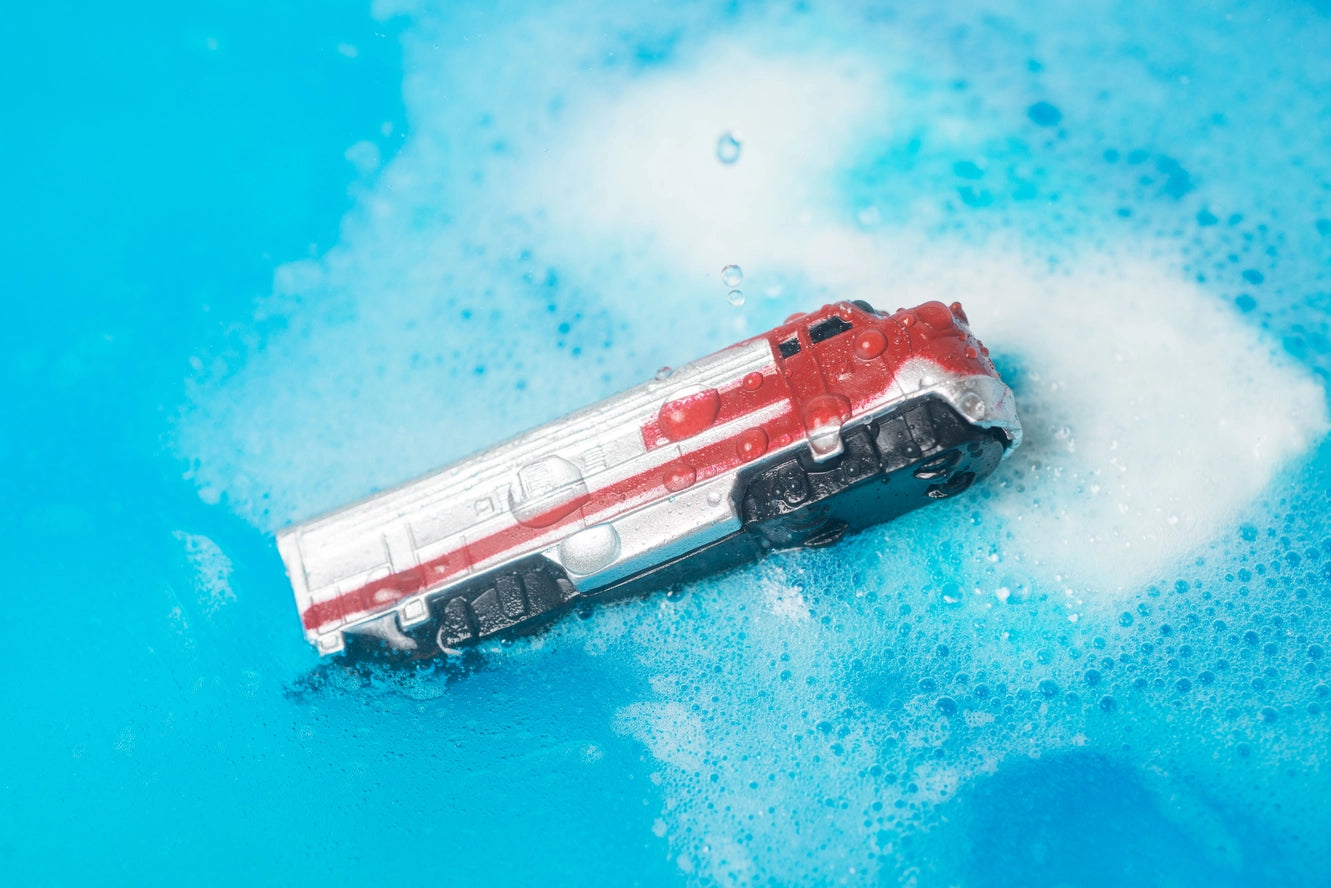 A train floats in the middle of a melted mass of Train Surprise Bath Bomb.