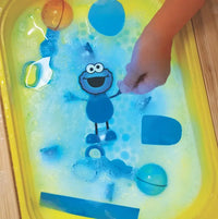 Sesame Street Cookie Monster Glo Pals Light-Up Sensory Toy glowing in tub.