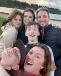 Family of six gathered together smiling at the camera