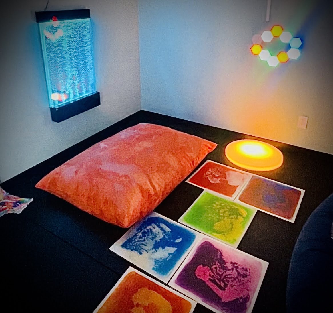 sensory room with color gel floor tiles, bubble wall and bean bag
