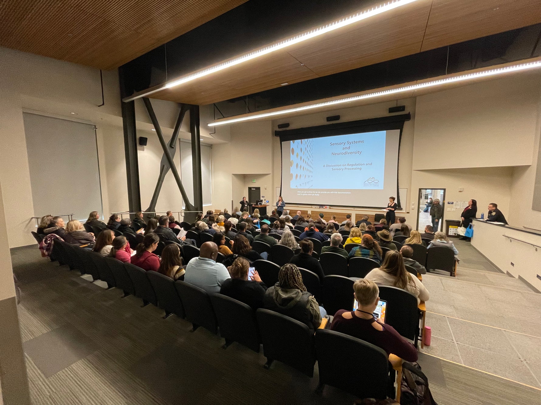 Auditorium filled with people watching a presentation