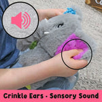 A child holds onto Ellie the Mini Sensory Elephant's ears to crinkle them.