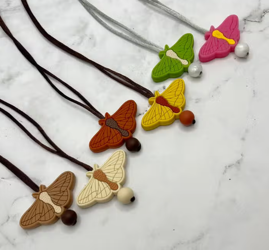 A colorful array of the Moth Fidget Necklace.