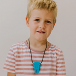 A child with light skin tone and short blonde hair wears the blue Robot Pendant.