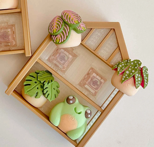 The Greenhouse Plant Shelf Clicker Fidget Keychain 2x2 revealing its detachable components.