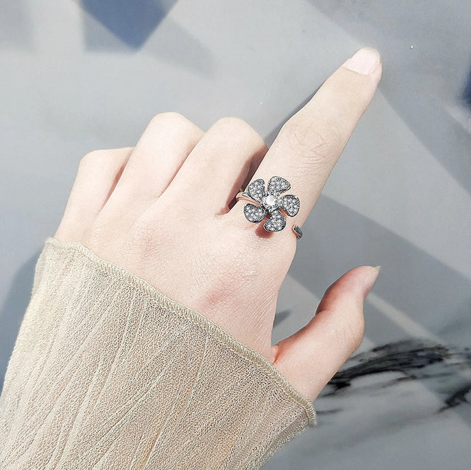 A hand wearing the Windmill Fidget Ring in Solid Copper with Cubic Zirconia.