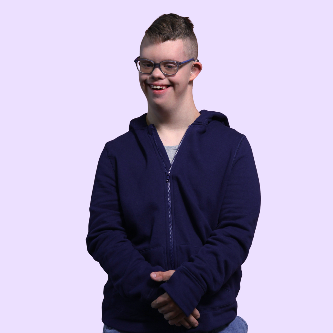 An adult poses with their hands in front of their torso wearing the Navy Adult QuietSense™ Zippered Sound Reducing Sensory Hoodie.
