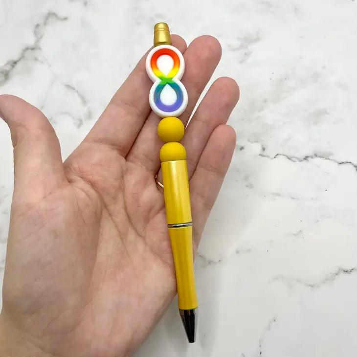 A hand holding the Autism Acceptance Chewy Fidget Pen.